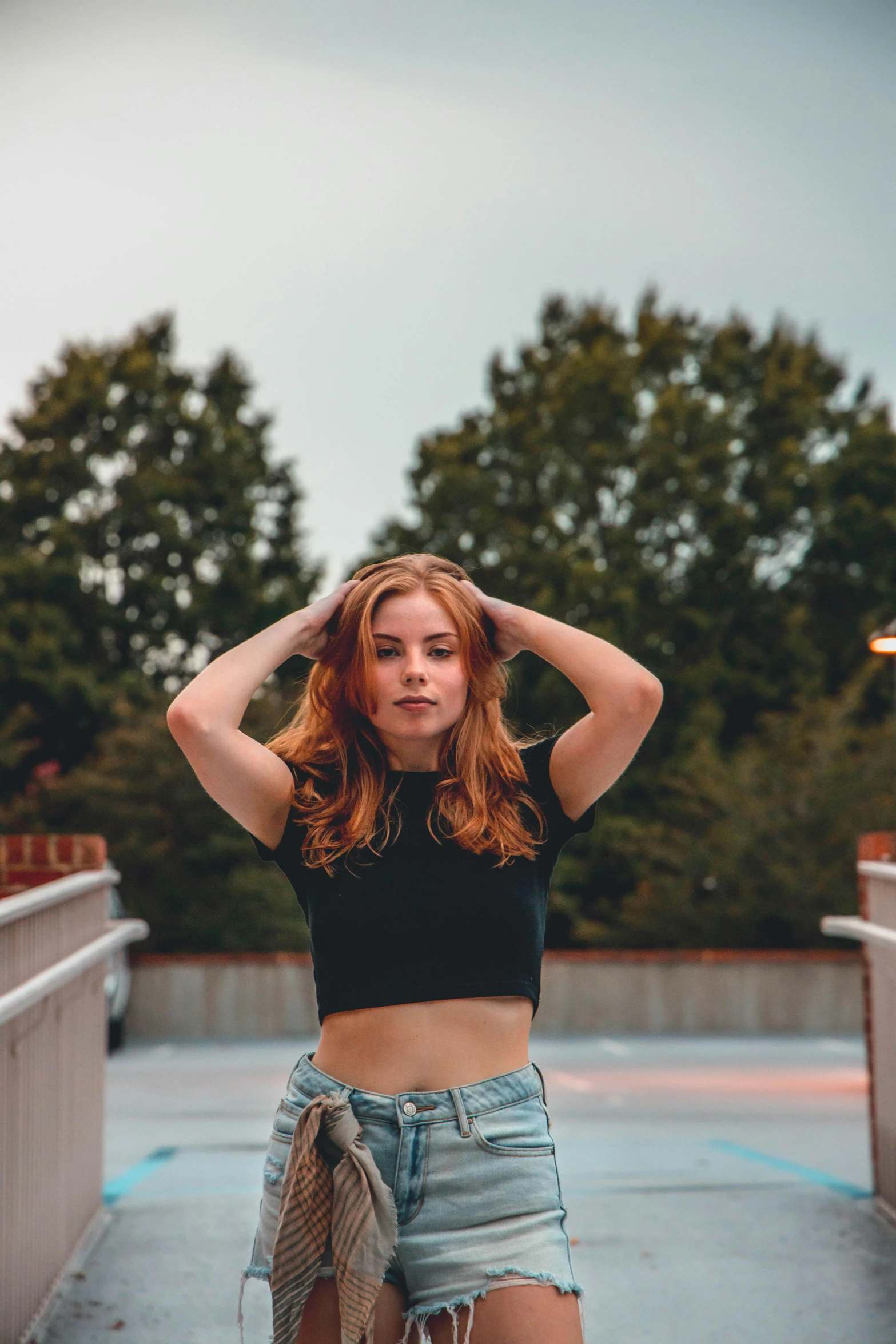 a young woman posing with her arms behind her head