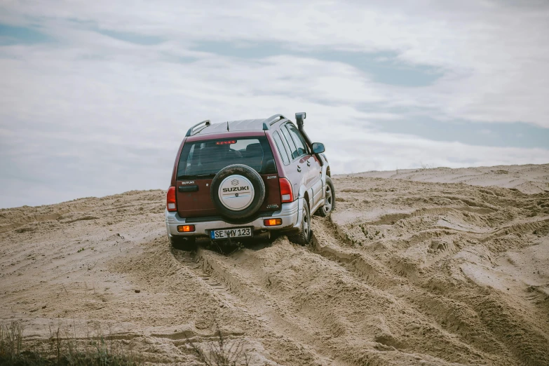 a van parked on a dune with the roof off