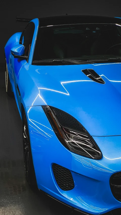 a blue sports car is parked in a room