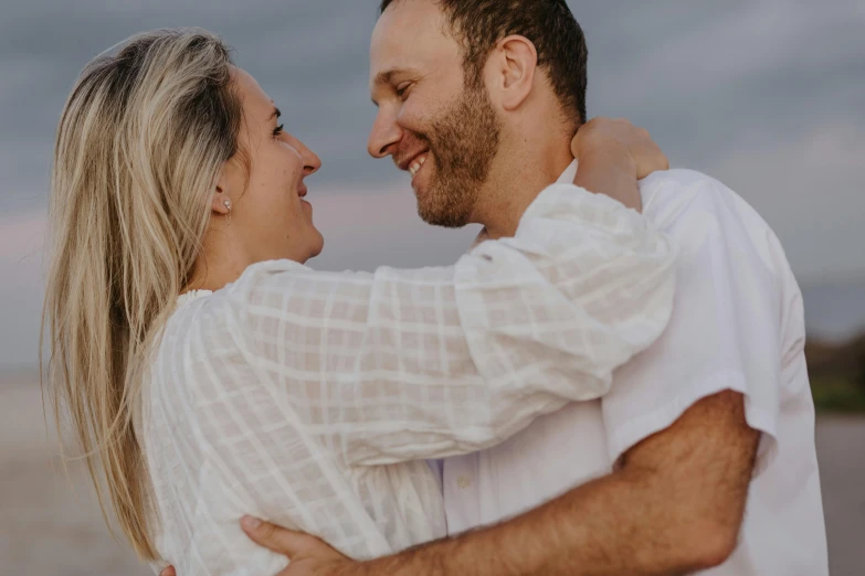 a couple hugging in an emce by the beach