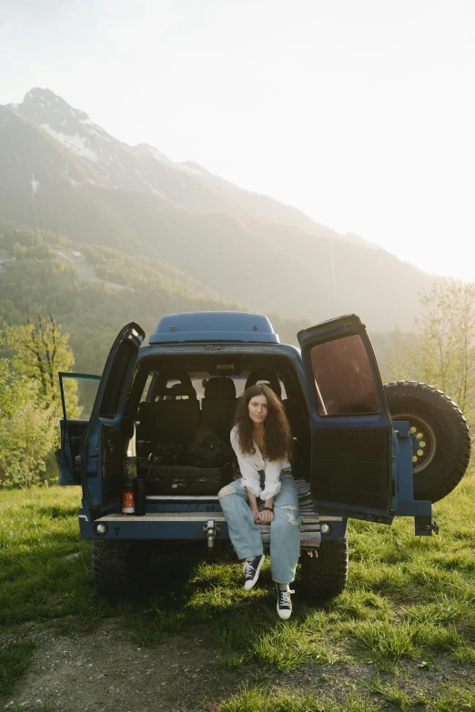 a person sitting in the back of a blue pickup truck