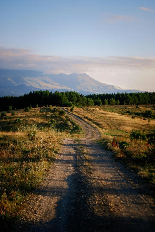 a dirt road that is going to the top of a hill