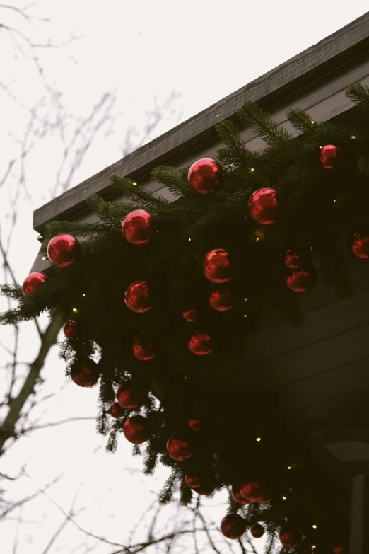 an elegant set of red balls hanging on the roof of a house