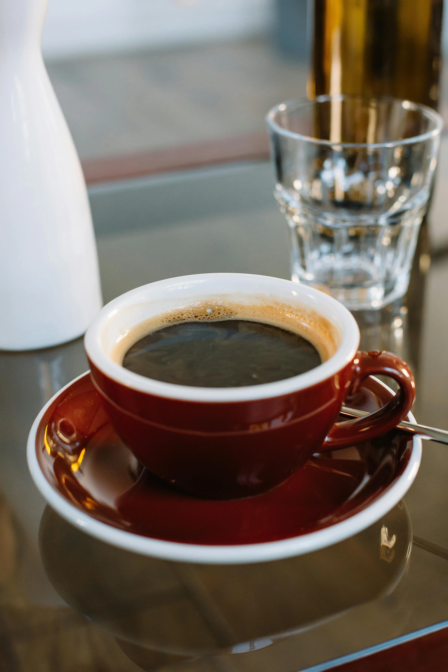 a coffee cup and a drink glass on a table