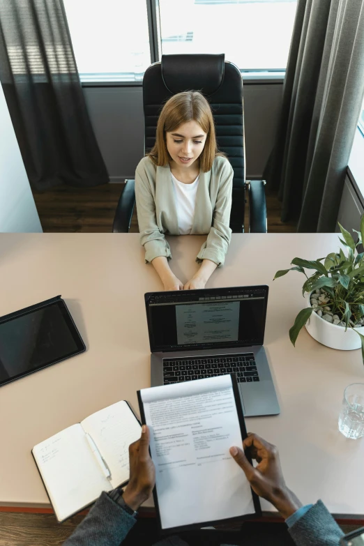 a woman working on her laptop while the man is holding his notes