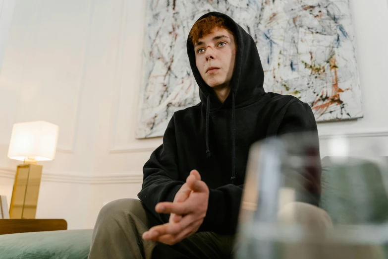 man with hooded sweatshirt and hands outstretched in front of him