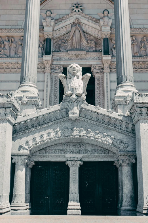 the front entrance to an old building with statues on it