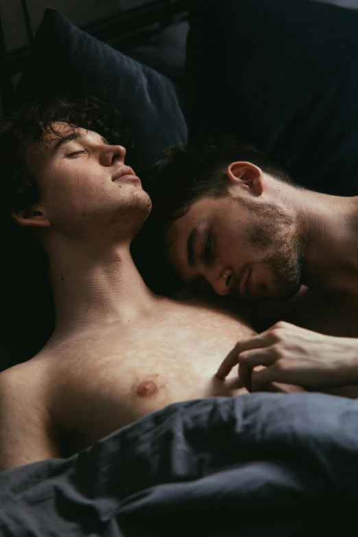 two men are lying down side by side