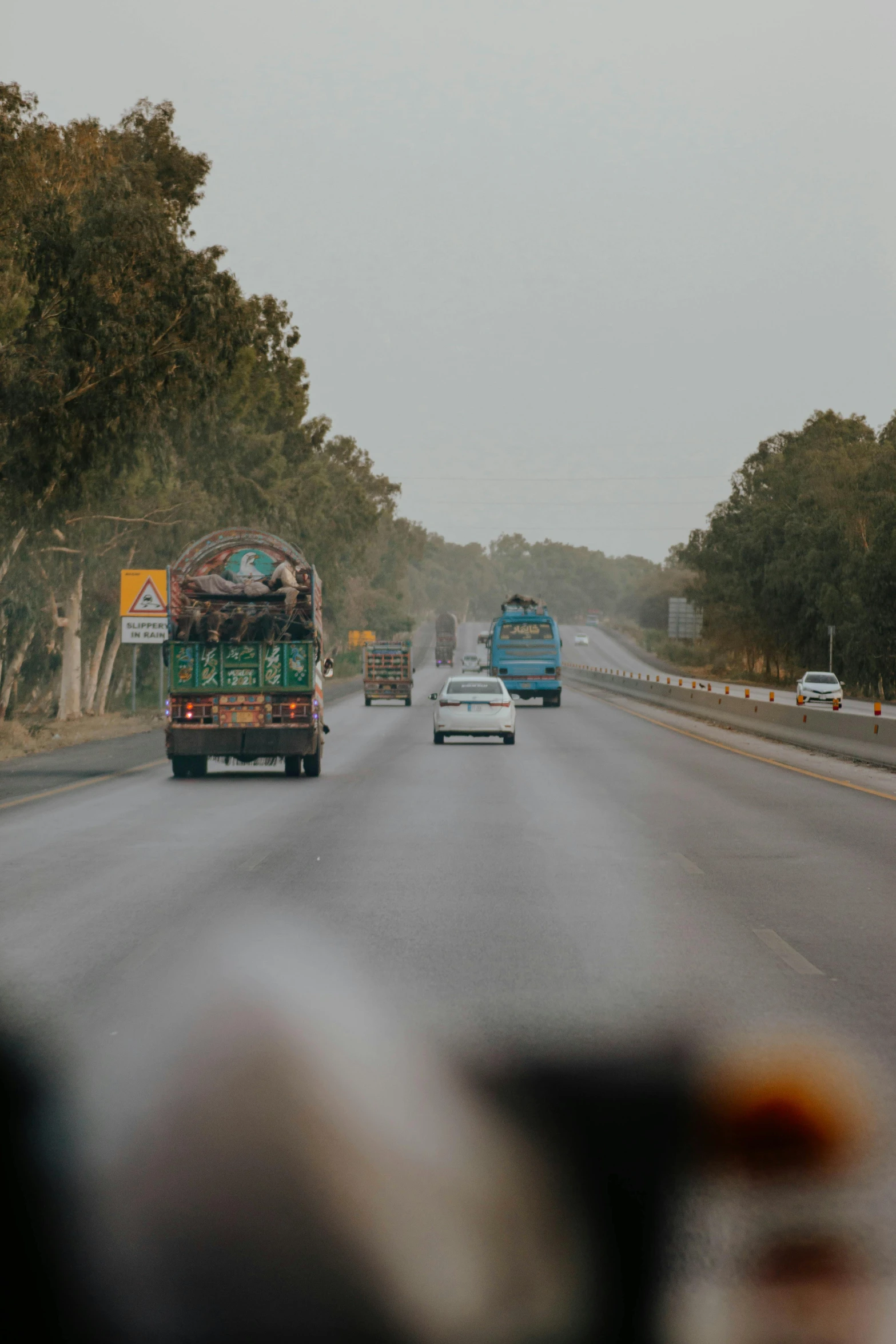 the view from inside the vehicle of a street with traffic