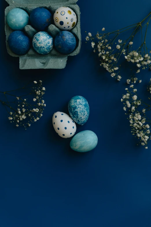 some blue easter eggs in an egg box