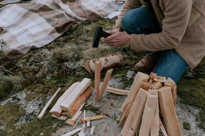 a person holding an axe next to various pieces of wood