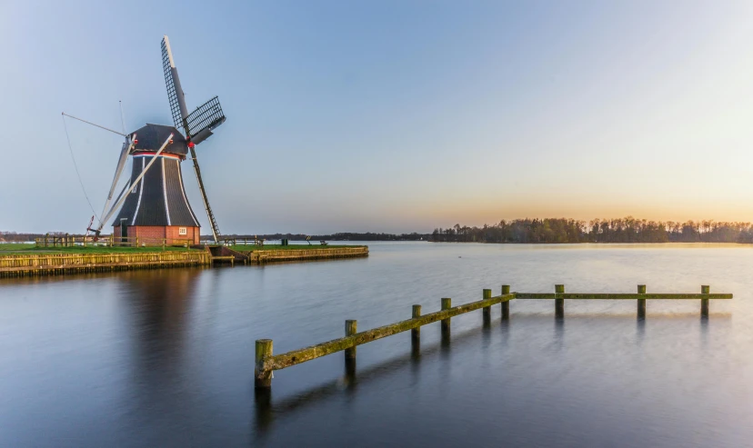 a lake with a windmill in the distance