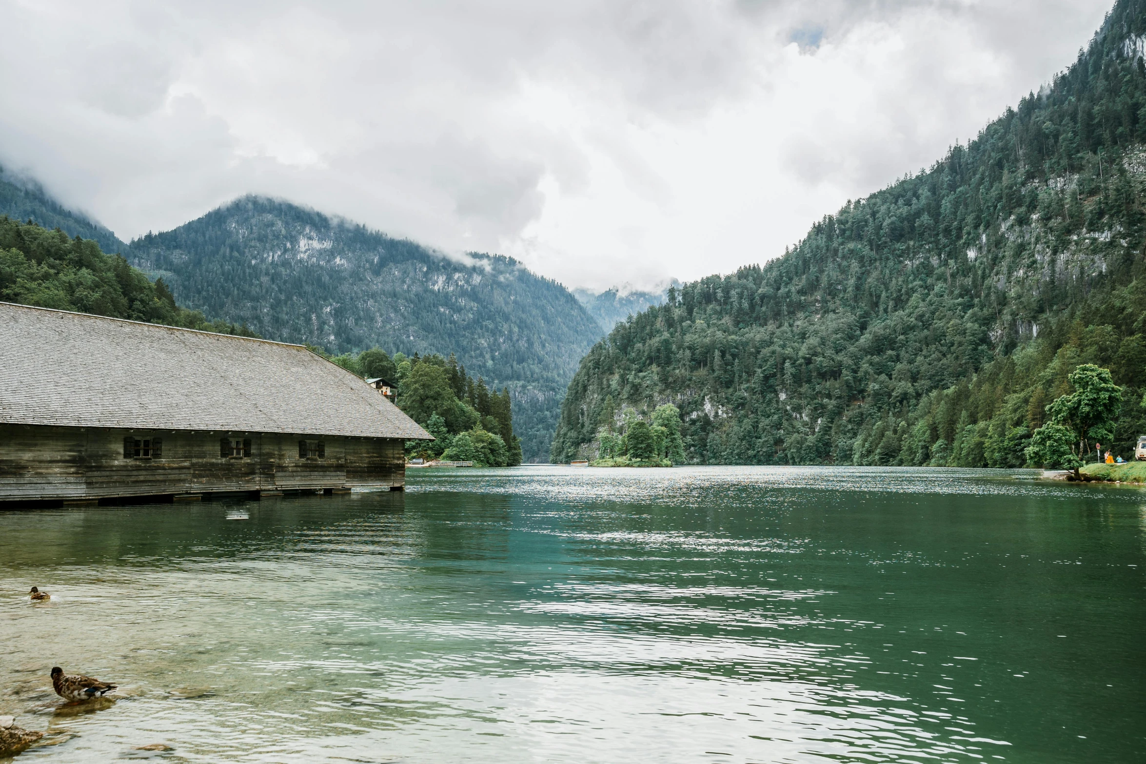 an old boat is at the dock next to the mountains