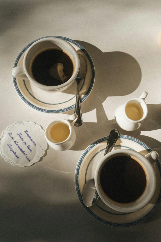 a table topped with cups of coffee and two birds