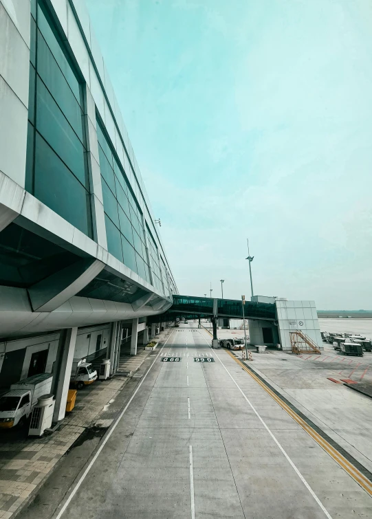 an empty runway of an airport with two planes in the background