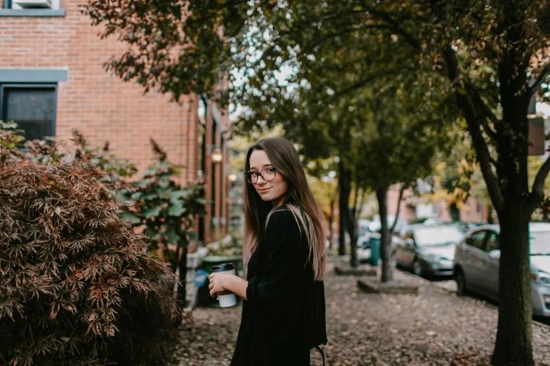 woman posing next to a tree in the fall