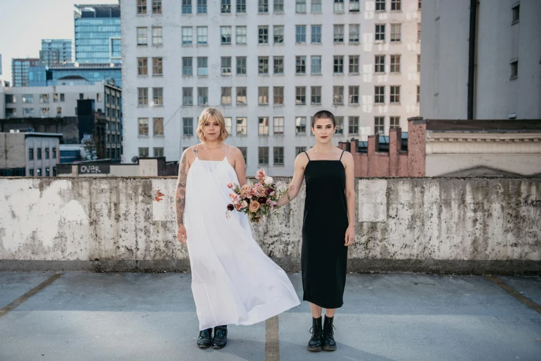 two women are wearing dresses and shoes posing for a picture