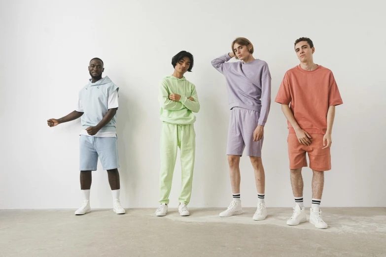 four men in shorts are standing in front of a white wall