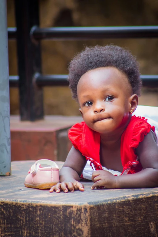 a baby girl lying on the ground with her mouth open