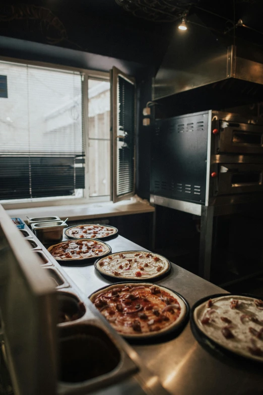 four pizzas sitting on top of a counter