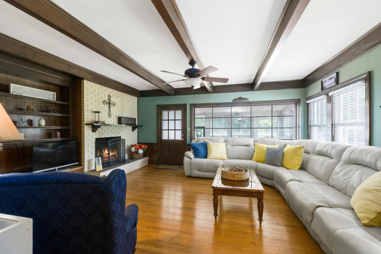 a living room has a wood floor and a ceiling fan