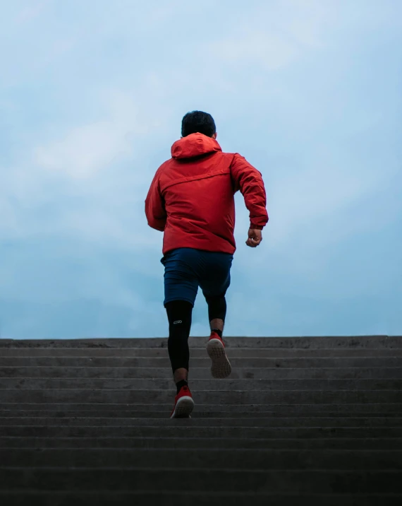 a man in red jacket running down steps