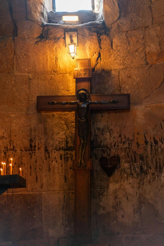 a wooden cross on the side of a stone building