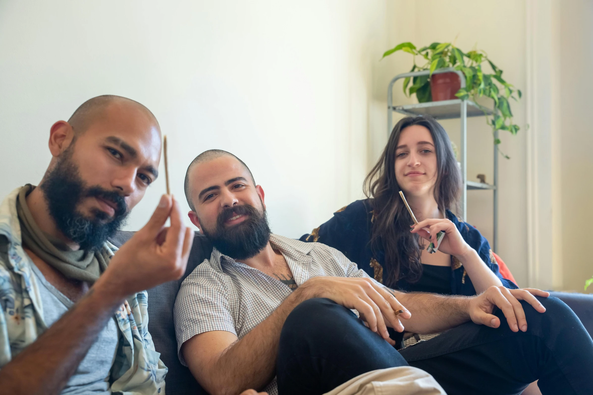 two men and a woman sitting on a couch