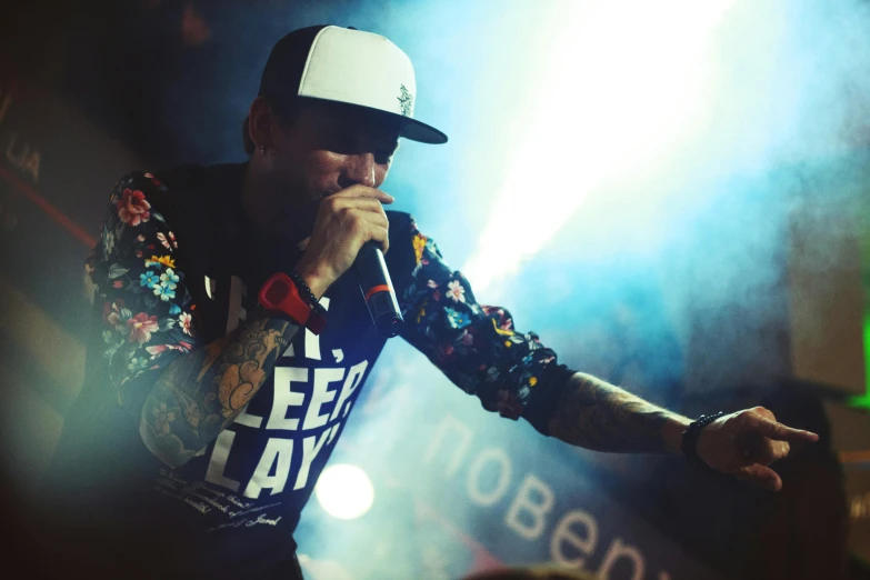 man singing into microphone during a concert with a crowd watching