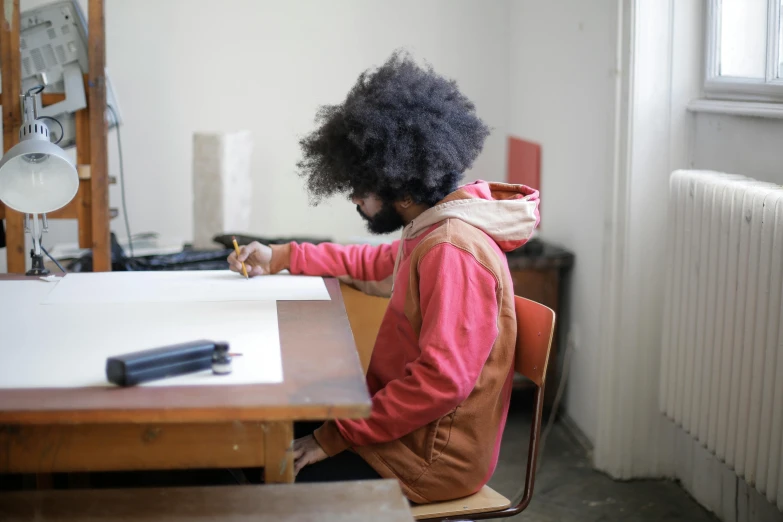 a woman sitting at a table working on furniture