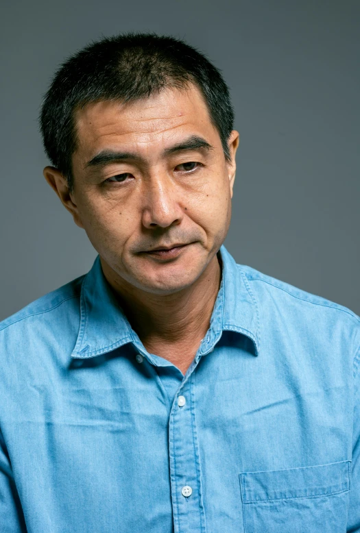 a man wearing blue shirt posing for a picture