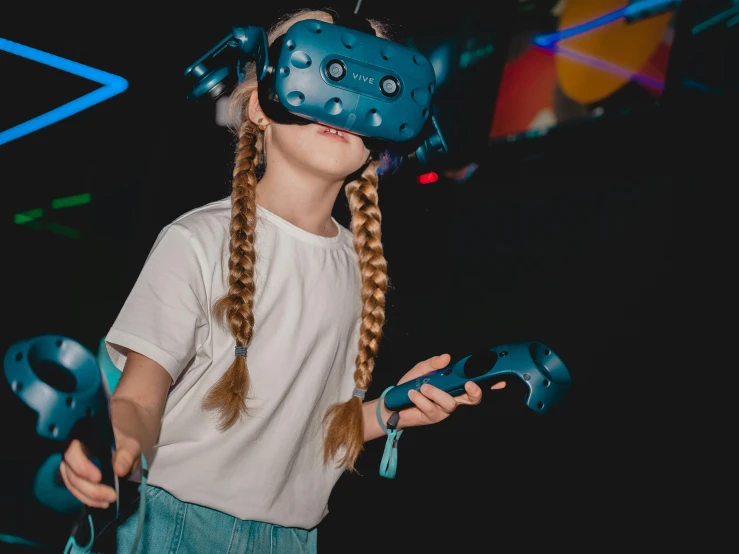 a little girl wearing a blue virtual reality headset