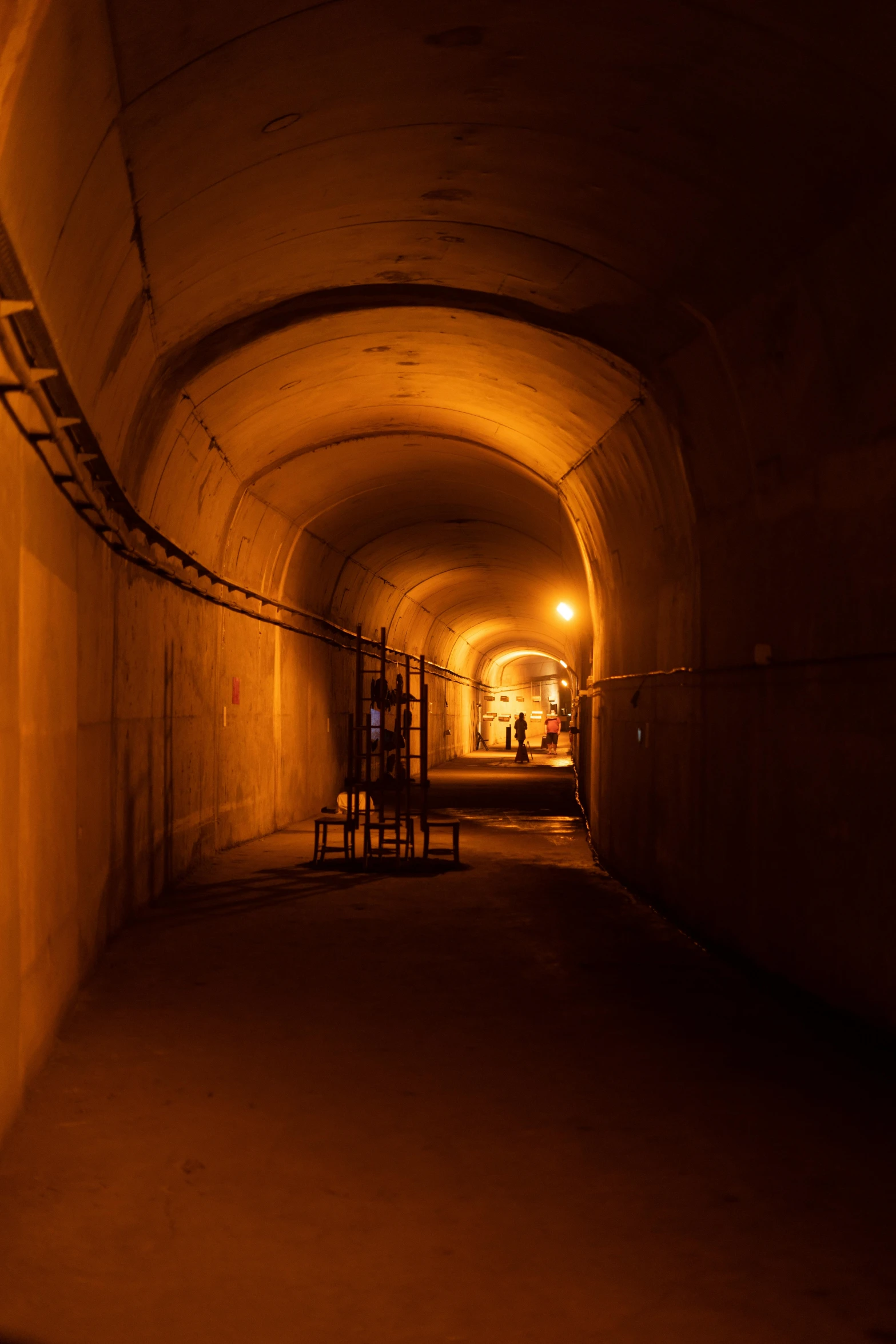 a tunnel in the side of a building with tables underneath