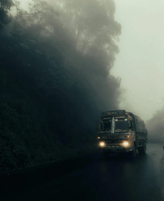 an old time bus traveling on a misty road