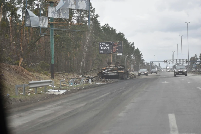 a destroyed truck on a rural road near tall trees