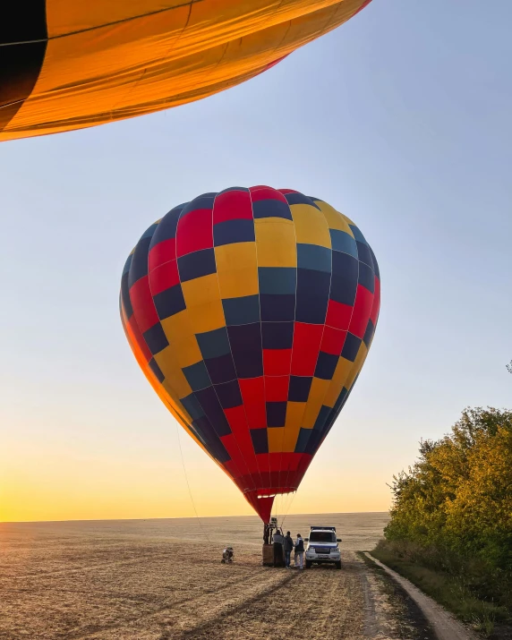 a  air balloon is shown flying over a car in the desert