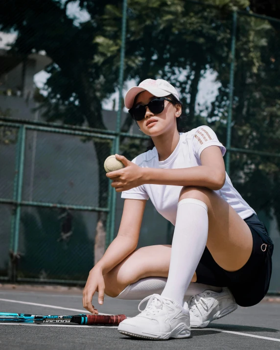 a girl is kneeling down playing tennis on a court