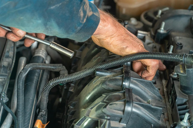 a person is working on a vehicle's motor engine