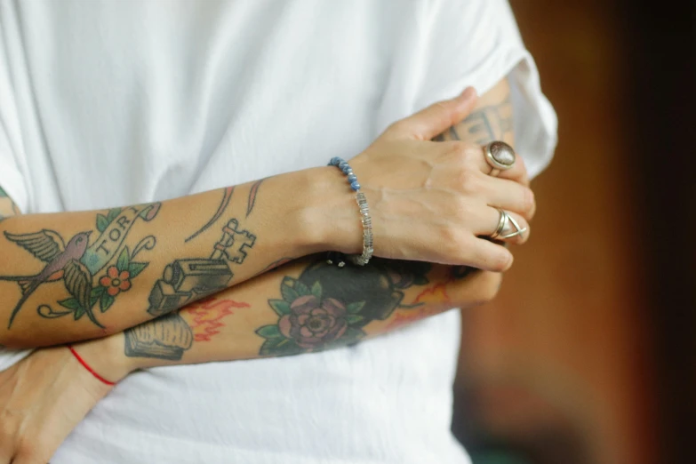 a tattooed arm with celets on top