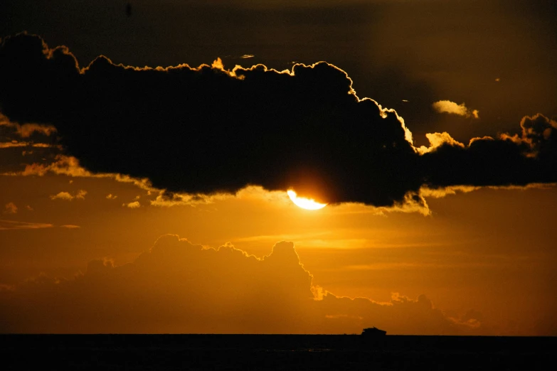 a very bright sun is in the distance with dark clouds