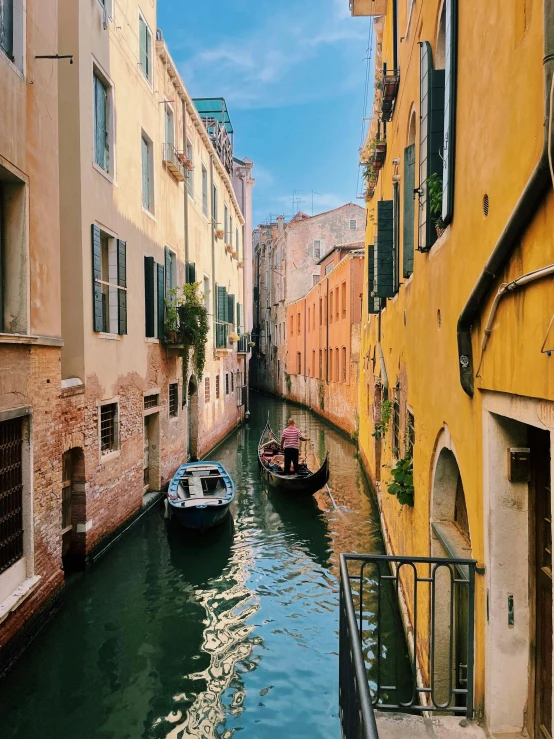 two boats in a canal between the buildings