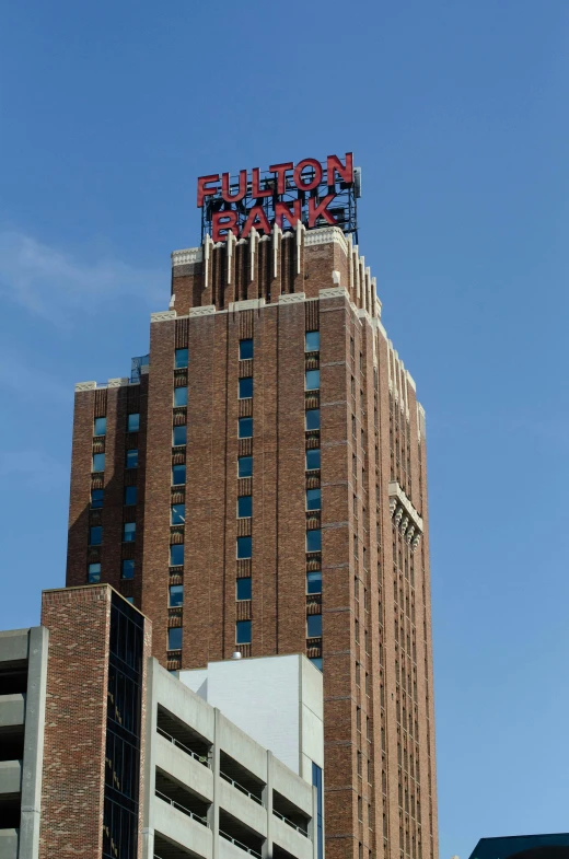 a tall brick building with a sign on top