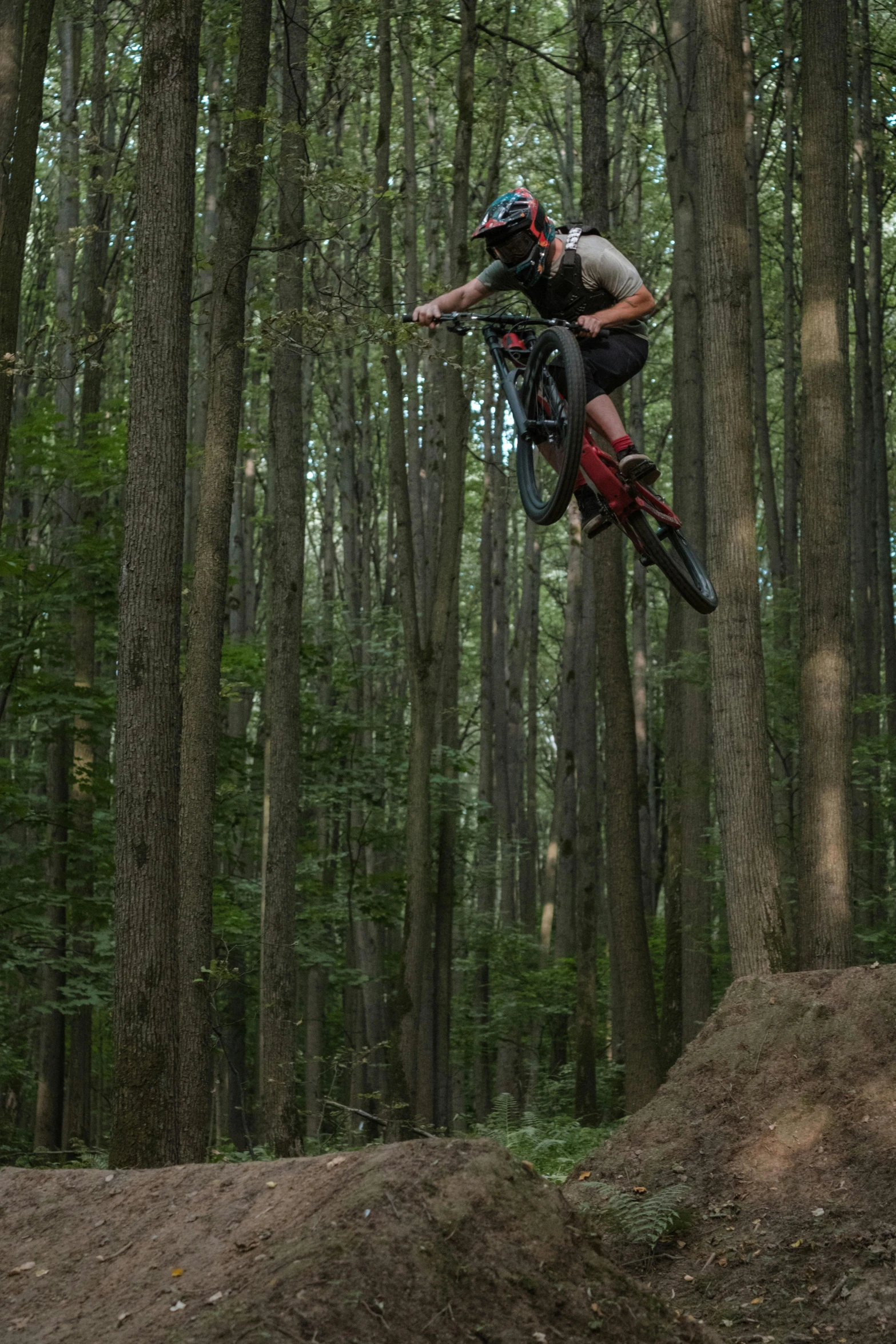 the rider jumps his bike over a slope of mud