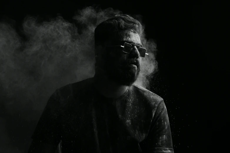 man with glasses on standing in smoke