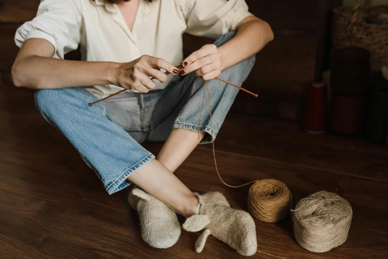 the woman is knitting a wool ball