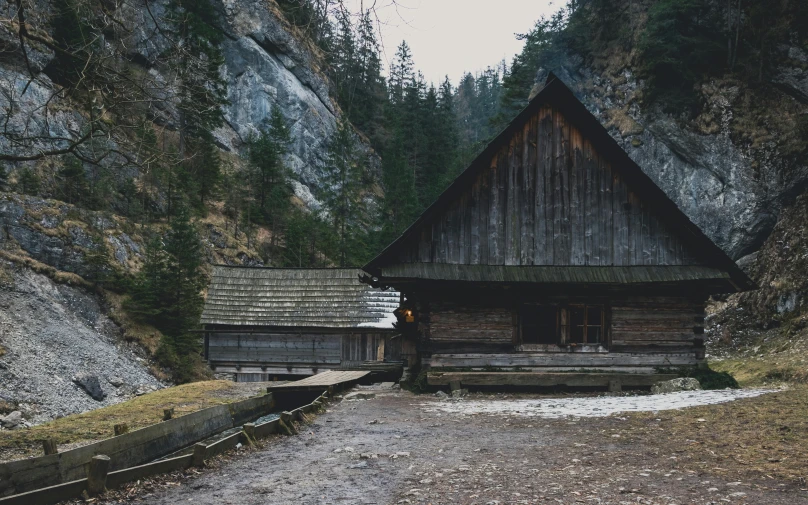 a small building is in the middle of mountains