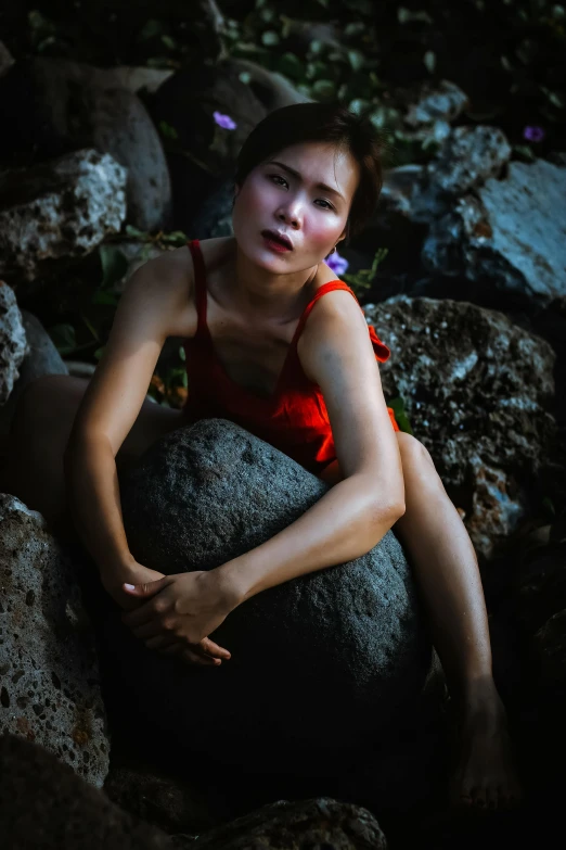 a woman is sitting on top of a rock