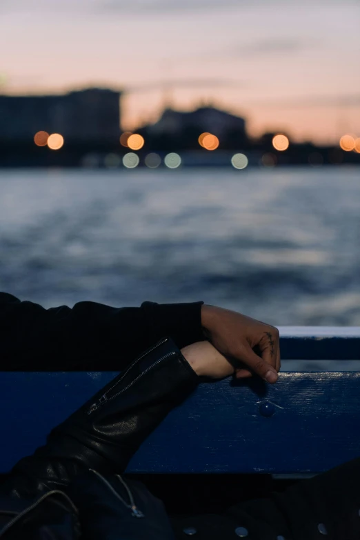 a person sitting on a boat holding a cigarette