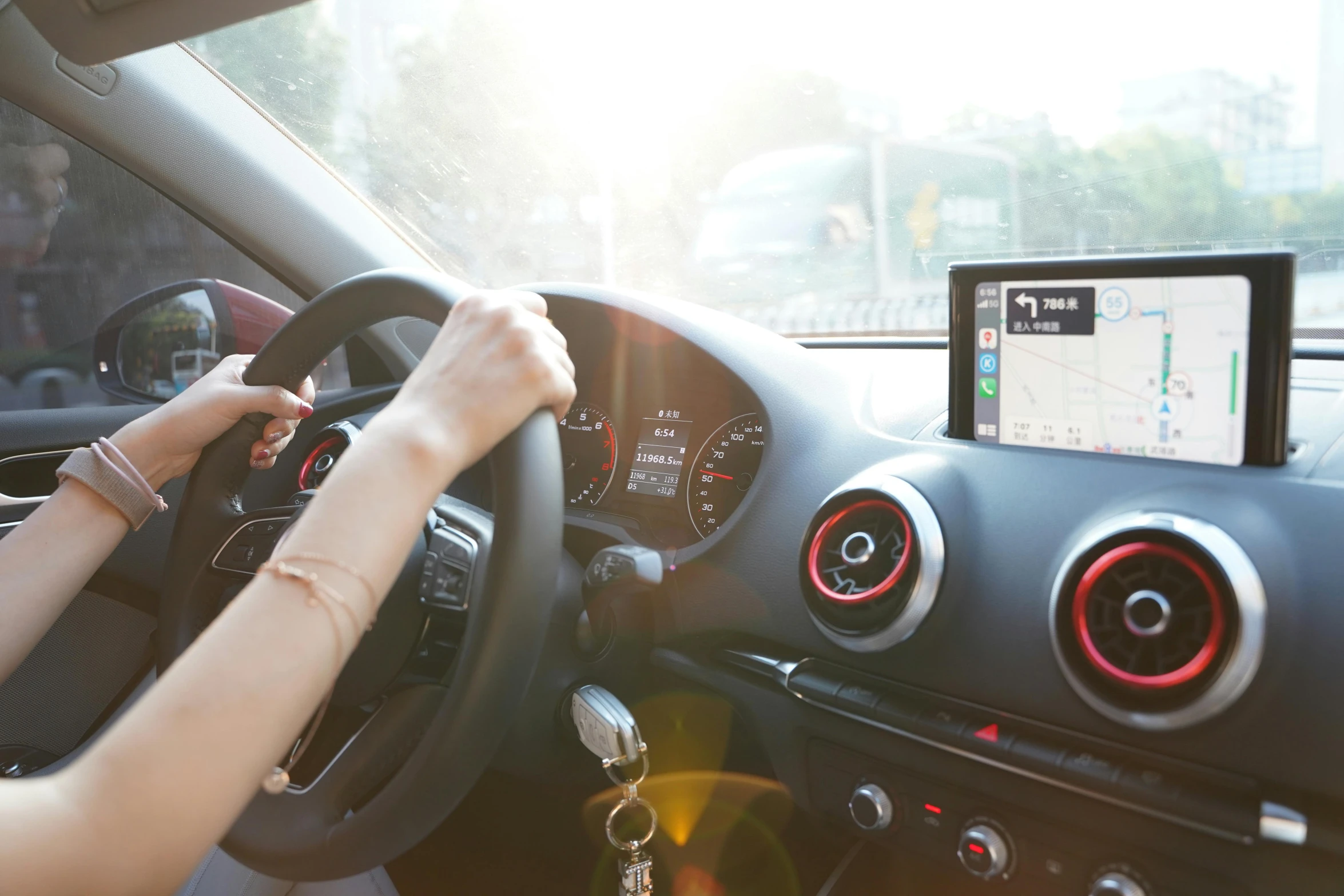 a woman driving on a road with her hands on the wheel