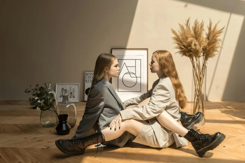 two girls sitting on the floor wearing tall boots